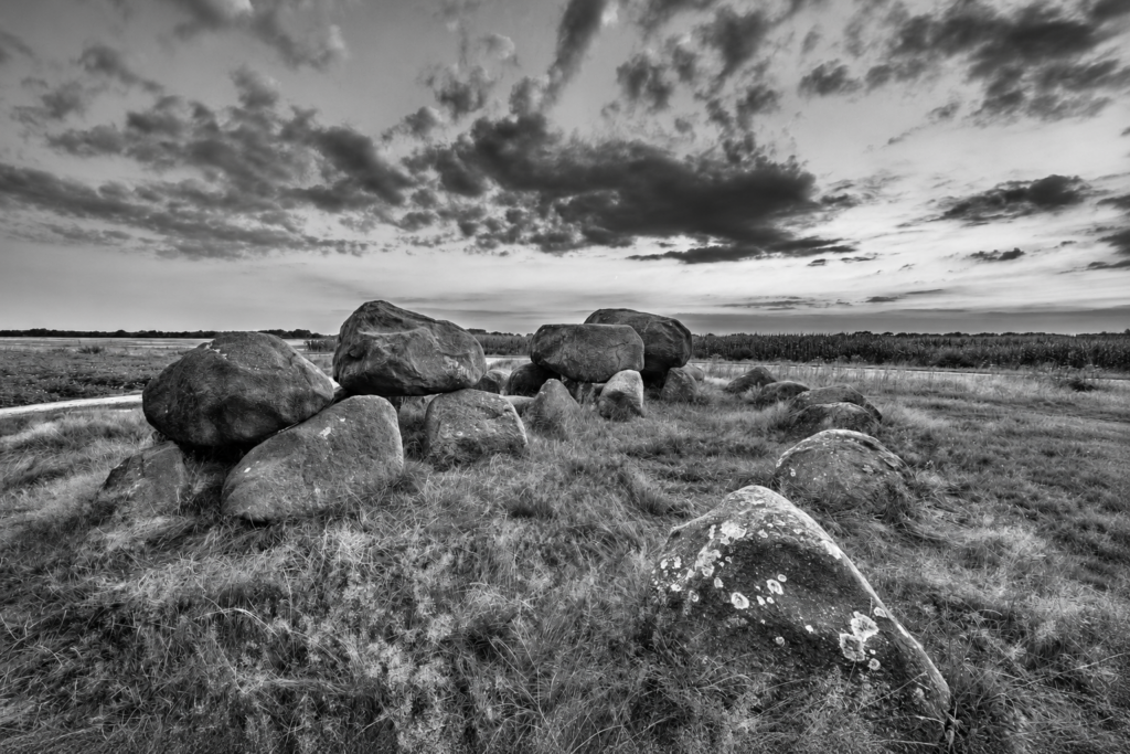 Hunebed in het Drentse landschap met een indrukwekkende wolkenlucht.